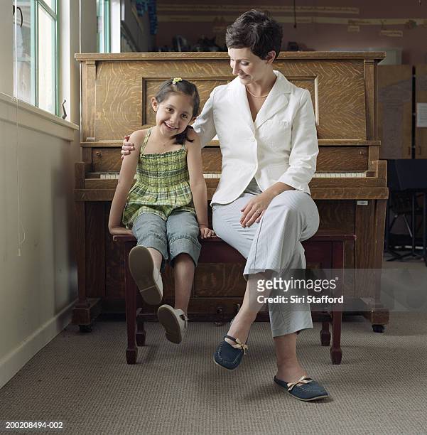 piano teacher sitting in front of piano with student (4-6), portrait - pianist front stock pictures, royalty-free photos & images