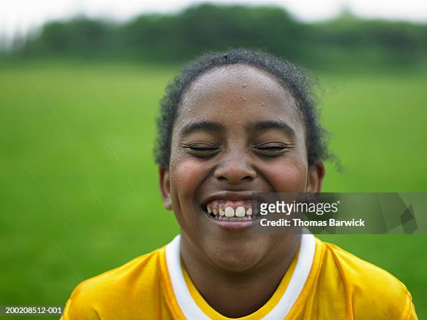 girl (10-12) in sports jersey smiling, eyes closed - african american girl wearing a white shirt stock pictures, royalty-free photos & images