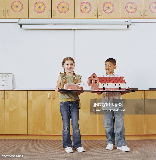 students (5-9) standing in classroom, holding model building, portrait - boy in briefs stock pictures, royalty-free photos & images