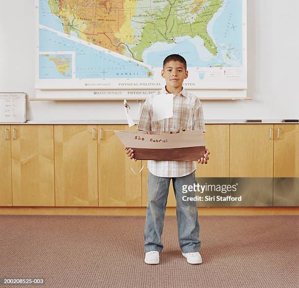 boy (5-9) standing in classroom, holding model of ship, portrait - boy in briefs stock pictures, royalty-free photos & images