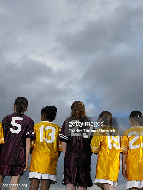 five girls (9-11) in sports jerseys standing side by side, rear view - sports uniform stock pictures, royalty-free photos & images
