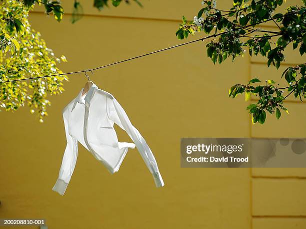 white shirt hanging on line, outdoors - white shirt stockfoto's en -beelden