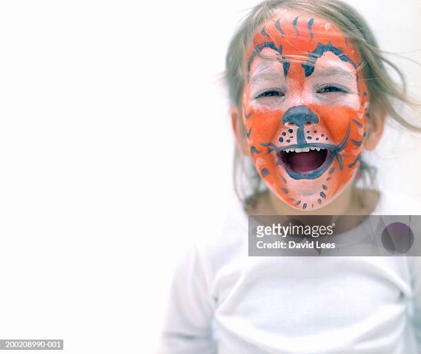 girl (2-4) with face painted as tiger, laughing, close-up - geschminkt gezicht stockfoto's en -beelden
