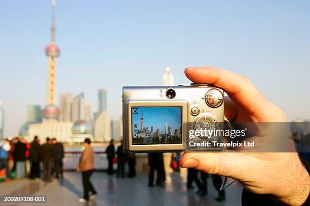 china, shanghai, tourist photographing pudong skyline, close-up - digitale camera stockfoto's en -beelden