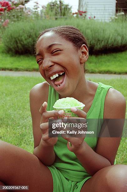 girl (10-12) holding snow cone, laughing, eyes closed - snow cones shaved ice stock pictures, royalty-free photos & images