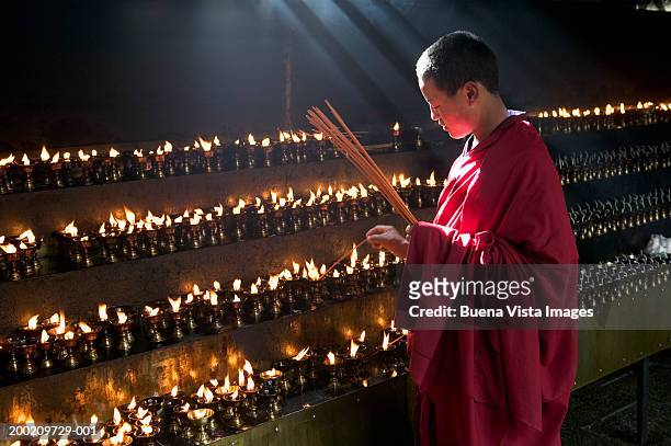 china, tibet, buddhist monk lighting insense at jokhang monastery - チベット ストックフォトと画像