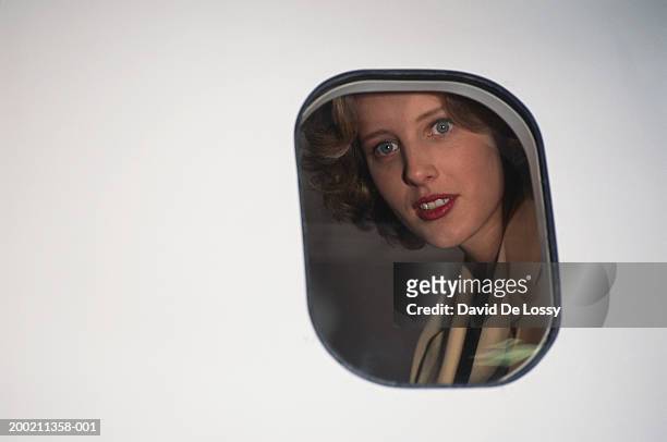 woman looking out through airplane window, view from outside - airplane window exterior stock-fotos und bilder