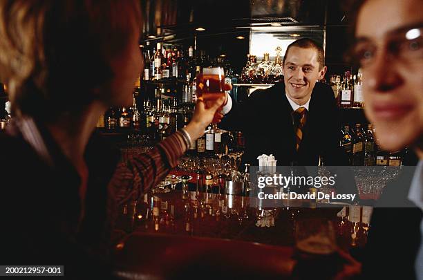 bartender giving women beer, at bar counter - beer white background stock pictures, royalty-free photos & images