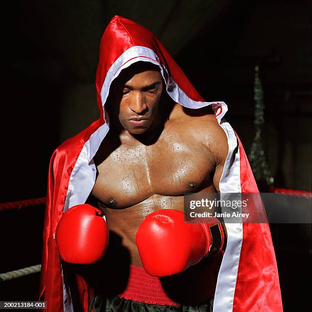 young male boxer wearing hooded cape in ring - peignoir de boxe photos et images de collection