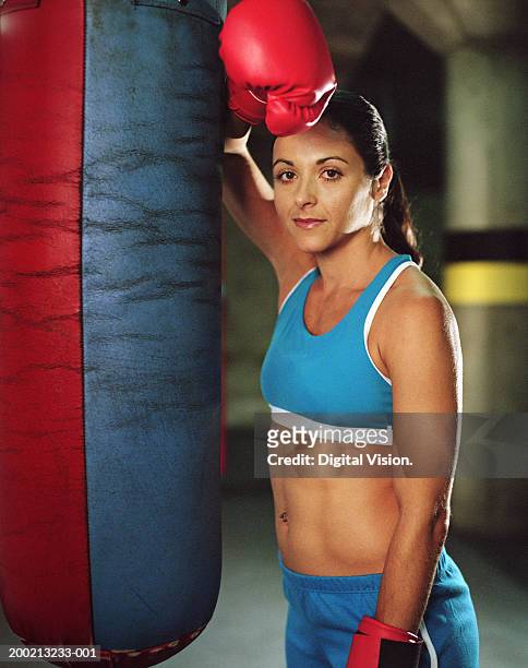 young female boxer resting arm on punch bag, portrait - gym resting stock pictures, royalty-free photos & images