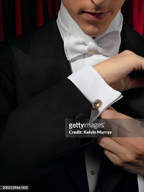 man wearing tuxedo, adjusting cufflink, mid section, close-up - cufflinks stock-fotos und bilder