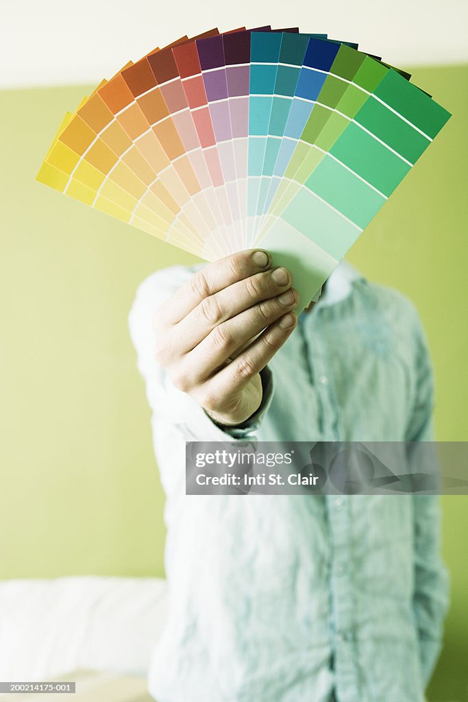 Young man holding up color samples