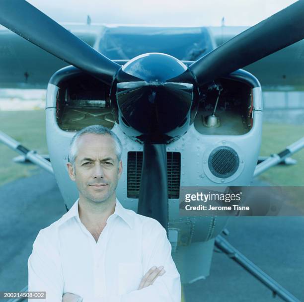 mature man standing by plane, arms crossed, portrait - propeller airplane bildbanksfoton och bilder