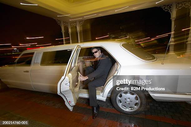 young man getting out of limousine, wearing sunglasses, portrait - limo night stock pictures, royalty-free photos & images