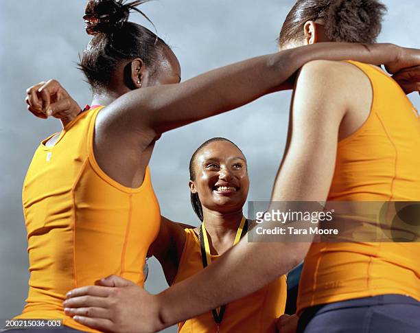 three young sportswomen embracing, smiling - champions day three fotografías e imágenes de stock