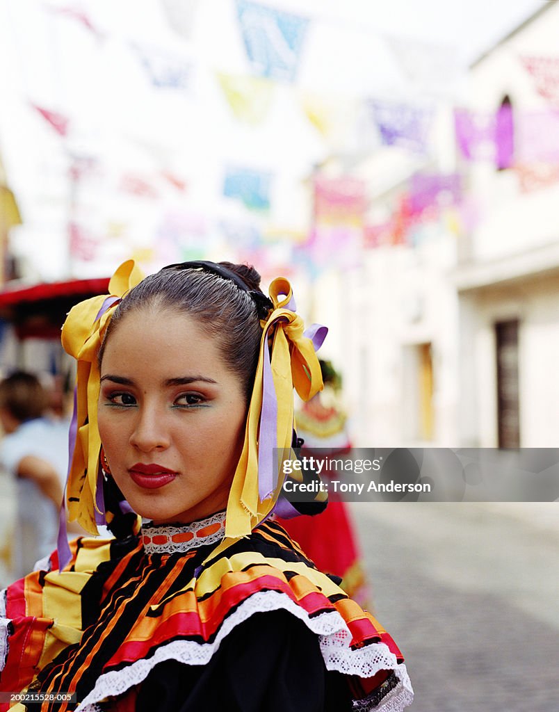 Young woman wearing traditional dress at fiesta, close-up, portrait