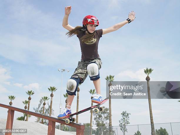 teenage girl (14-16) skateboarding down rail - skateboard tennis shoe stock pictures, royalty-free photos & images