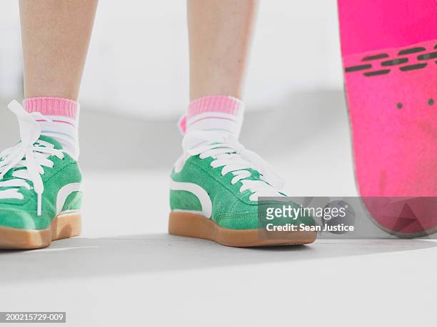 teenage girl (14-16) with skateboard, low section - green shoes stockfoto's en -beelden
