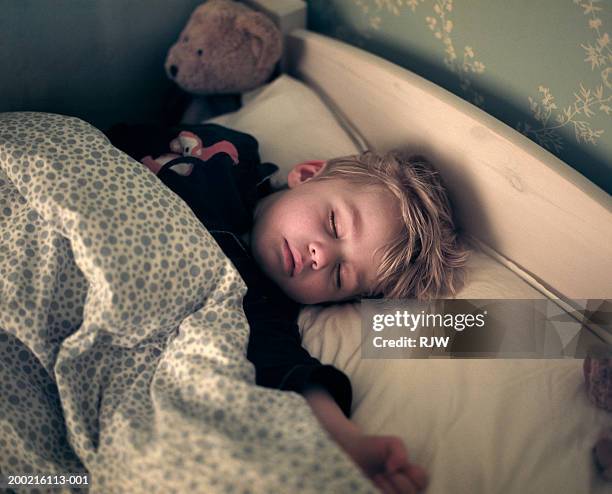 boy (2-4) sleeping in bed - sleeping toddler bed stock-fotos und bilder