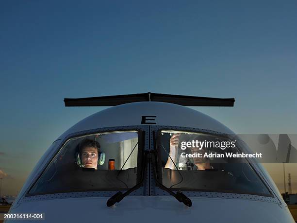 two pilots in cockpit of plane, view through glass - airplane front view stock pictures, royalty-free photos & images