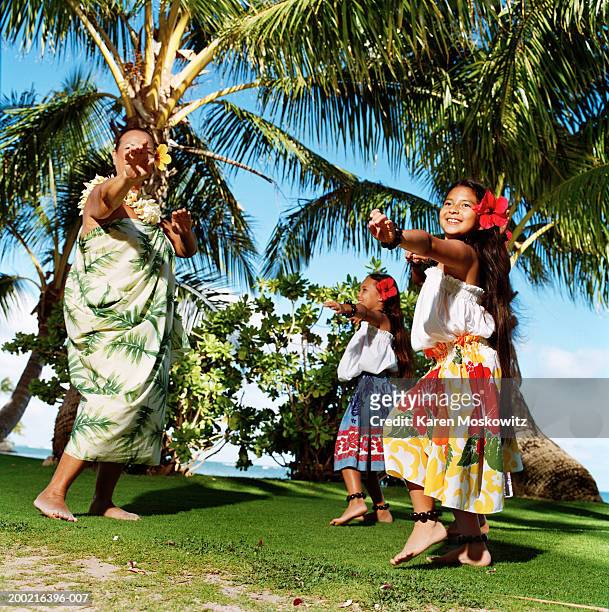 mature woman hula dancing with two girls (8-10), smiling - hula dancing stock pictures, royalty-free photos & images