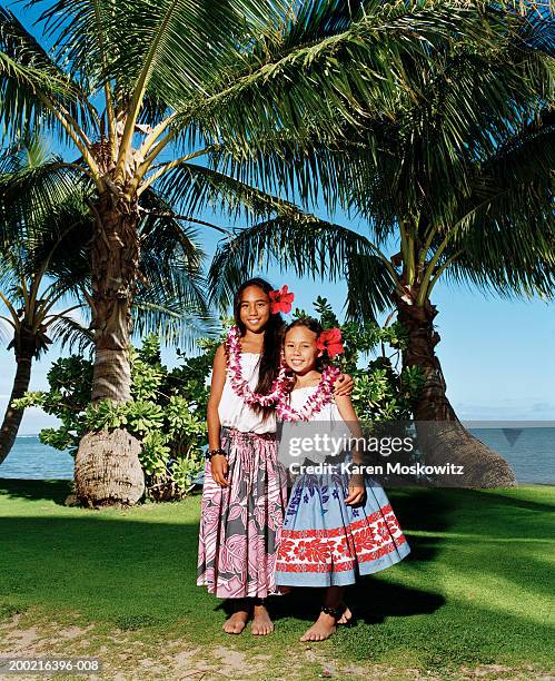 two girls (9-11) standing on beach, arms around each other, portrait - lei day hawaii stock-fotos und bilder