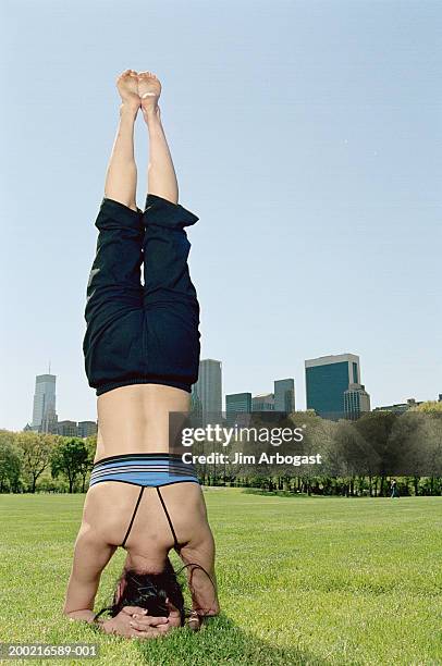 young woman standing on head outside, rear view - yoga headstand pose imagens e fotografias de stock