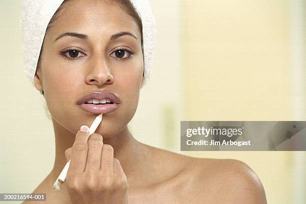 young woman applying make-up to lips, close-up, portrait - konturstift stock-fotos und bilder