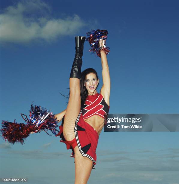 cheerleader, leg and arm raised, smiling, portrait - cheerleader high kick stock-fotos und bilder