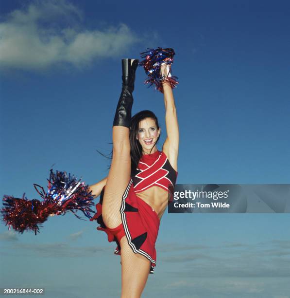 cheerleader, leg and arm raised, smiling, portrait - boot kicking stock pictures, royalty-free photos & images