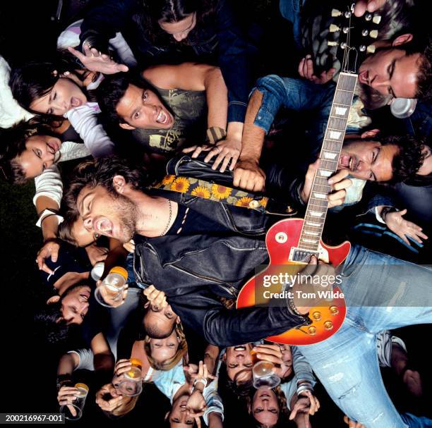 young male guitarist crowd surfing, portrait - être porté par la foule photos et images de collection