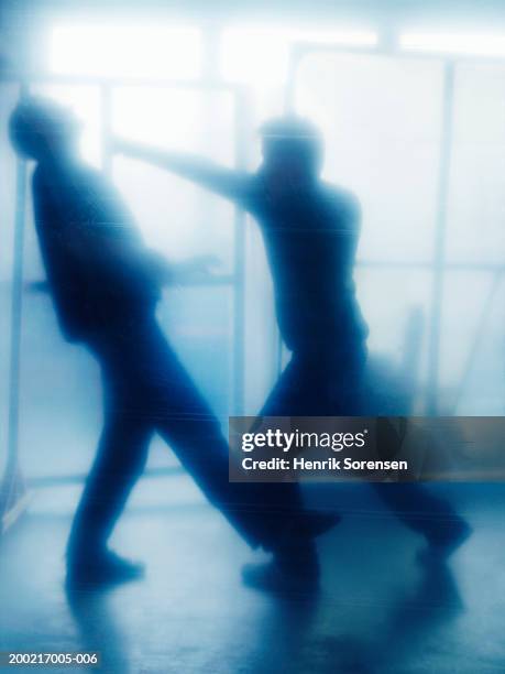 leaning backwards away from man throwing punch, side view (defocussed) - puñetazo fotografías e imágenes de stock