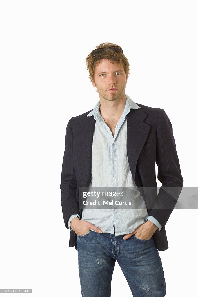 Young man standing with hands in pockets, portrait