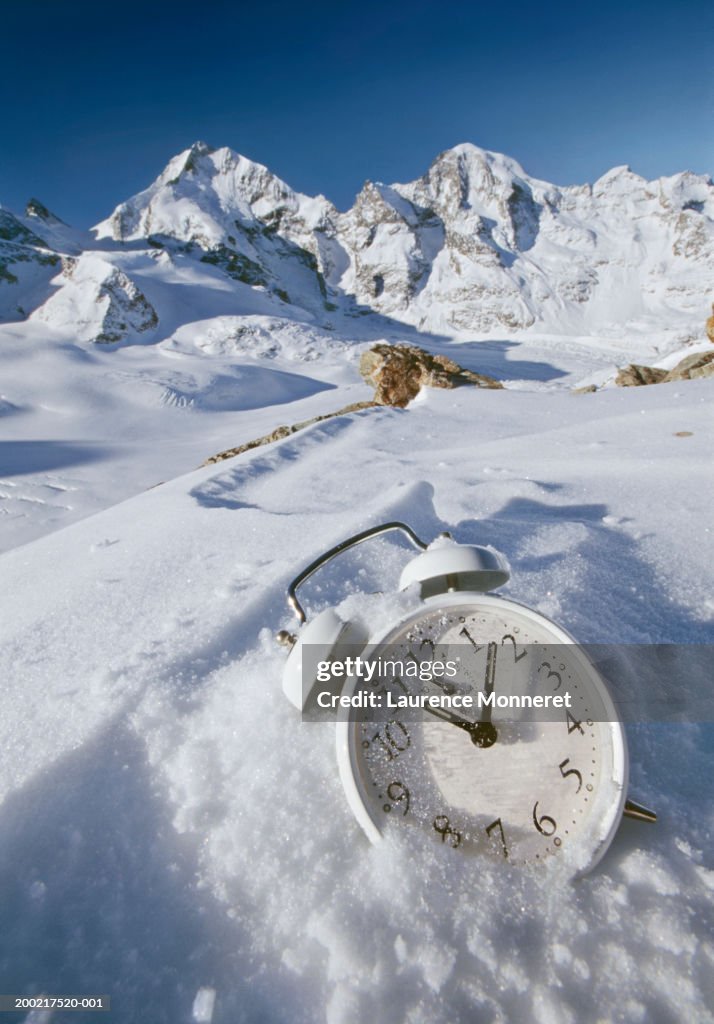 Alarm clock on ski slope, close-up