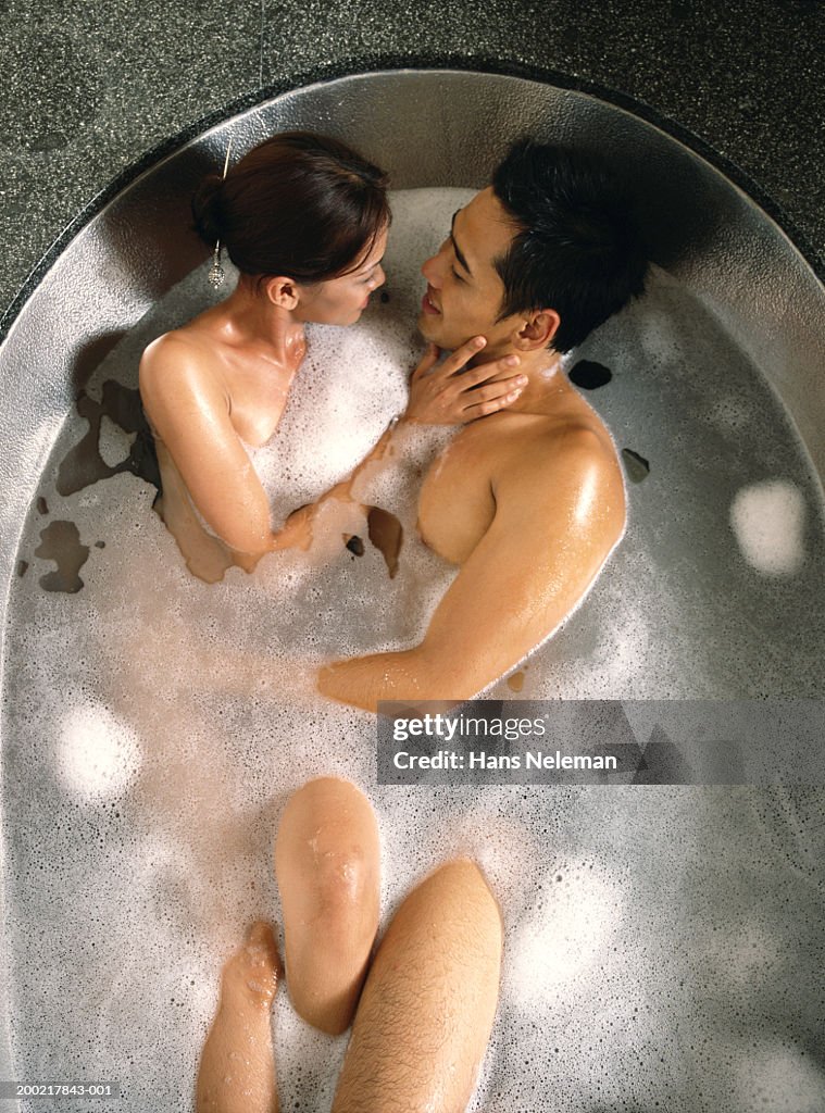 Couple embracing in bath, overhead view