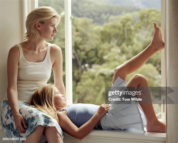 mother and daughter (9-11) relaxing on window sill - big tom stock pictures, royalty-free photos & images