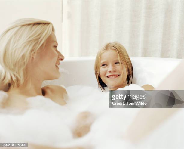 mother and daughter (9-11) relaxing in bath - woman bath tub wet hair stock pictures, royalty-free photos & images
