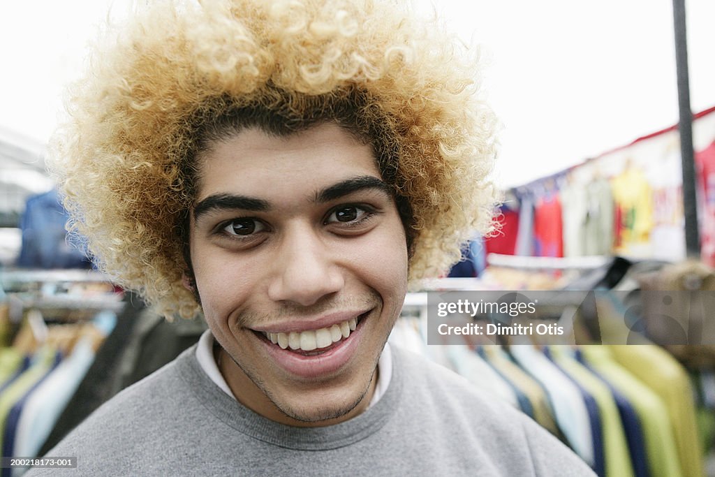 Young man with afro hair smiling, close-up, portrait