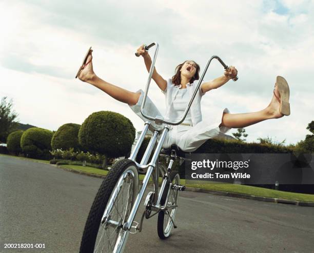 young woman riding bicycle, legs raised, yelling - legs apart stock pictures, royalty-free photos & images