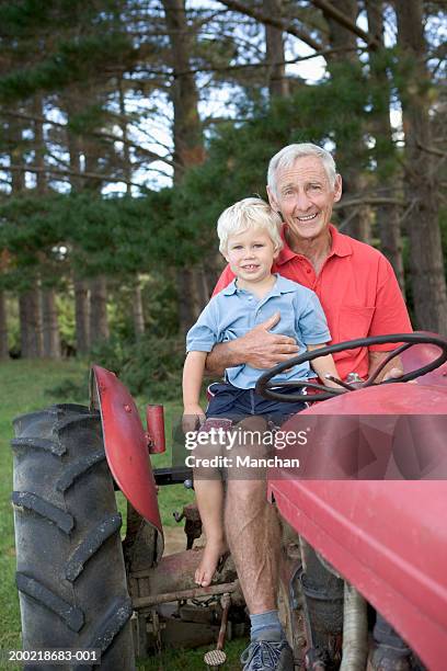 senior man on tractor with grandson (2-4), portrait - driving barefoot stock pictures, royalty-free photos & images