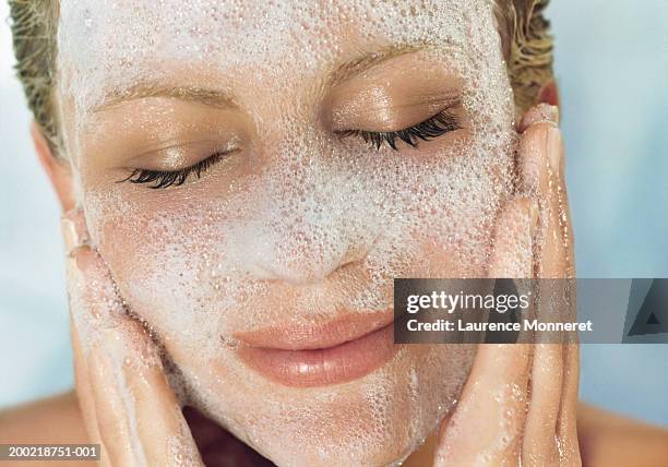 young woman washing face, close-up - facial cleanser stockfoto's en -beelden