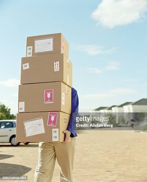 delivery man carrying stack of boxes, obscuring face - carrying box stock pictures, royalty-free photos & images