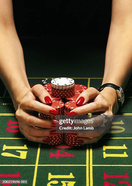woman pulling gambling chips towards her in both hands, close-up - greed stock pictures, royalty-free photos & images
