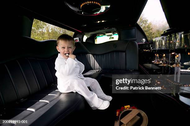 boy (2-4) sitting in limousine, holding spoon in mouth - silver spoon in mouth stock pictures, royalty-free photos & images