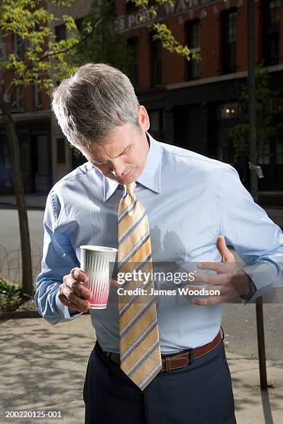 businessman outdoors, coffee spilt on shirt - stained shirt stock pictures, royalty-free photos & images