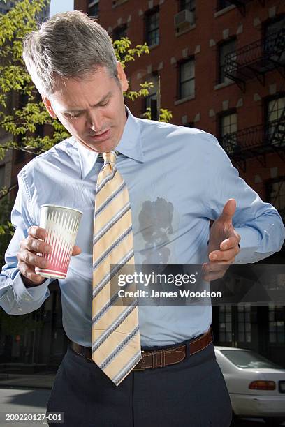 businessman outdoors, coffee spilt on shirt - 40's rumpled business man stockfoto's en -beelden