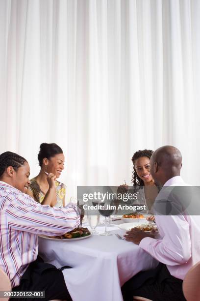 four young adults eating meal in restaurant, smiling - double date stock pictures, royalty-free photos & images