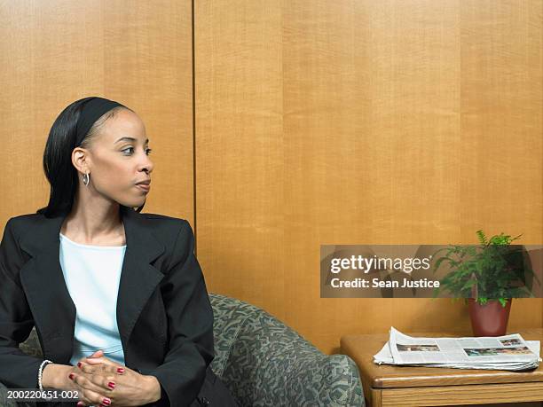 businesswoman sitting in waiting area - african american interview stock pictures, royalty-free photos & images