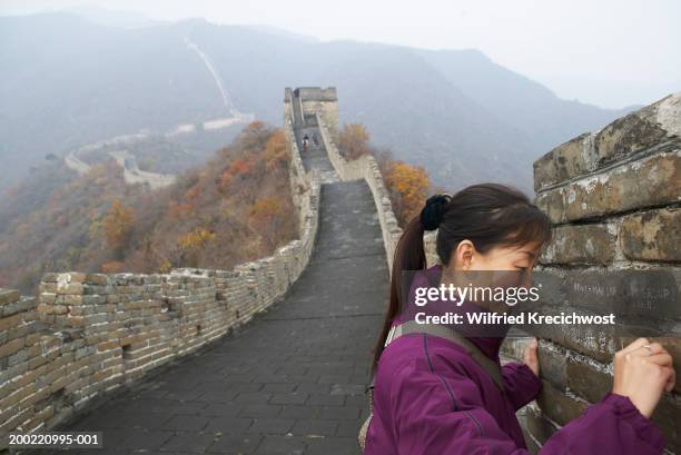 china, beijing, great wall, mutianyu, woman writing on wall, smiling - mutianyu stock pictures, royalty-free photos & images