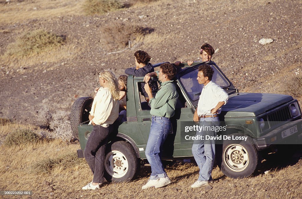 Group of young people standing by car, elevated view